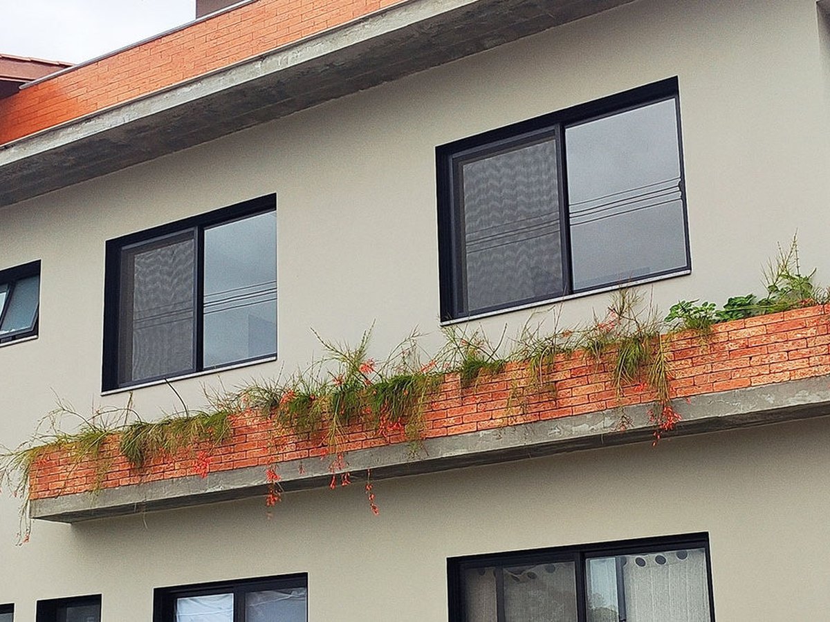 Fachada com esquadrias de alumínio e floreira em Garopaba