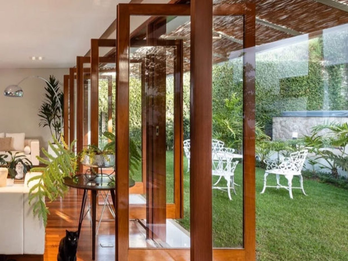 Fechamento em madeira e vidro entre sala e jardim